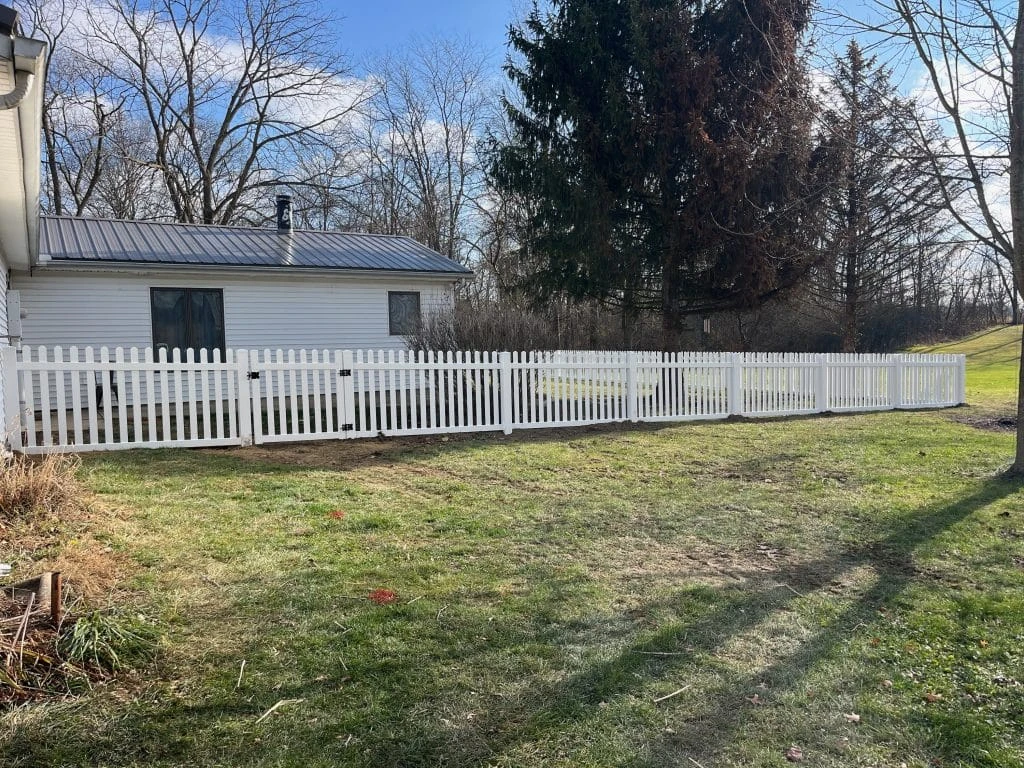 Roanoke fence company White vinyl picket fence installation in a residential backyard