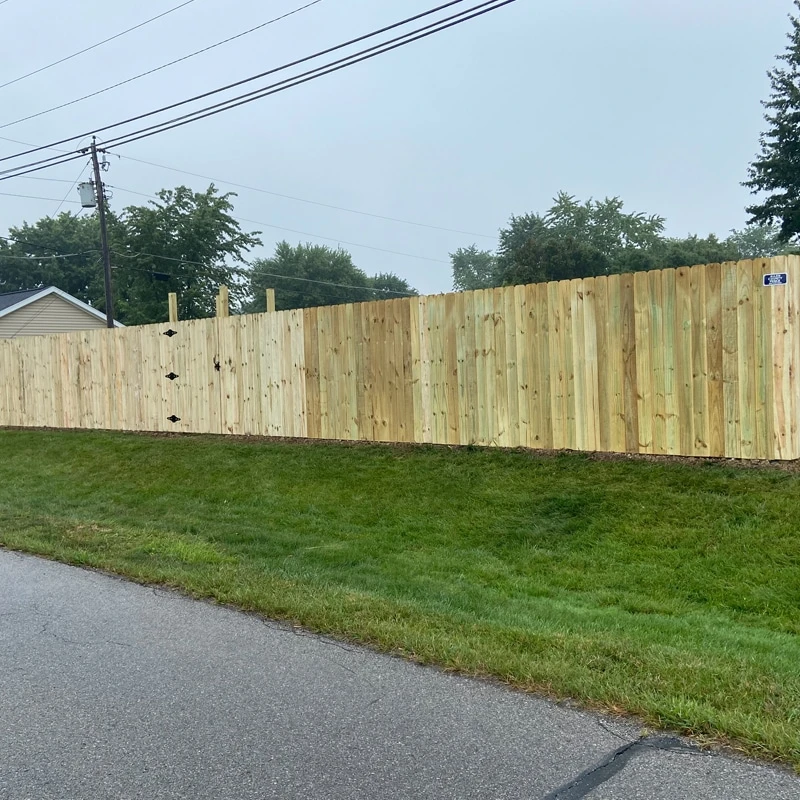 Roanoke fence company installation of New wood privacy fence installation on a sloped yard