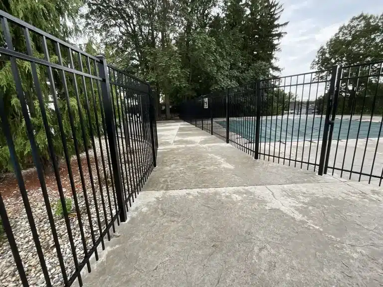 Close-up of a black aluminum pool fence with secure gate installation in Fort Wayne, Indiana